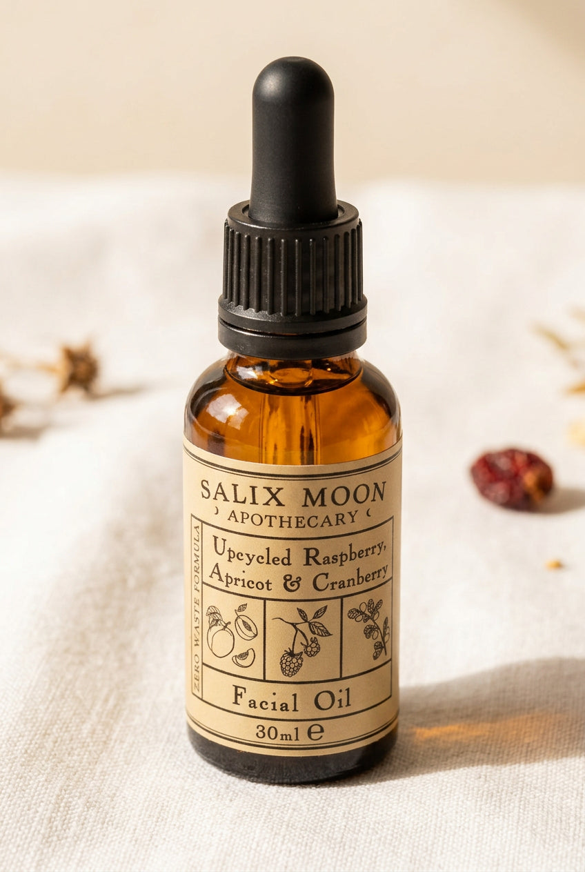 An amber glass dropper bottle of Salix Moon Apothecary Upcycled Facial Oil, featuring a black dropper cap and a beige label with botanical illustrations, set against a neutral linen background.