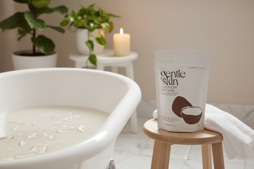 Coconoat Bath Soak lifestyle scene beside a premium roll-top bath with candle in background